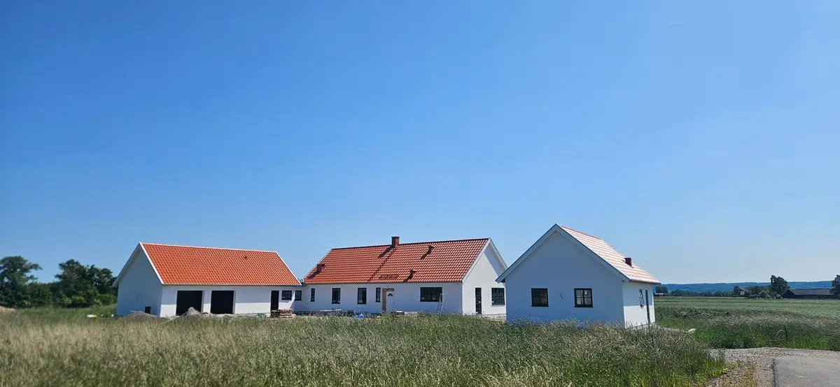 Vit nybyggd villa med flera byggnadsvolymer